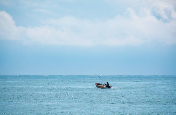A fisherman is sailing in a boat. Lonely fishing boat