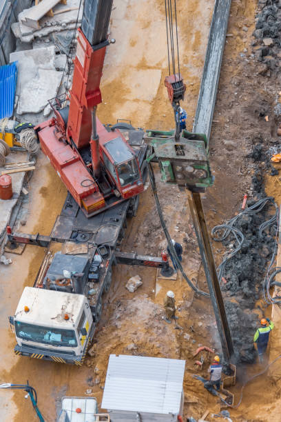istock Installation of piles at a building site using an outboard power plant for drilling soil. 1180244350