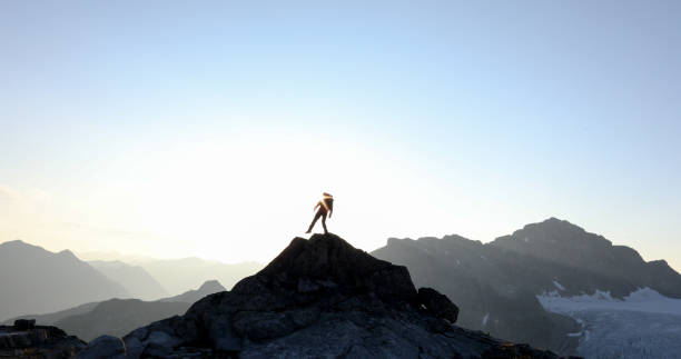 istock Mountaineer crosses summit ridge at sunrise 1180244611