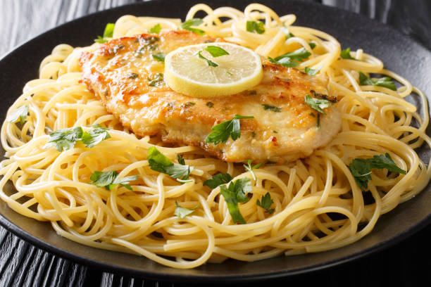 istock Traditional chicken Francaise with spaghetti with lemon sauce close-up on a plate. horizontal 1180244732