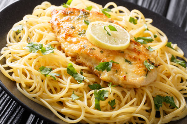 istock cooked chicken Francaise with spaghetti in lemon wine gravy close-up on a plate. horizontal 1180244777
