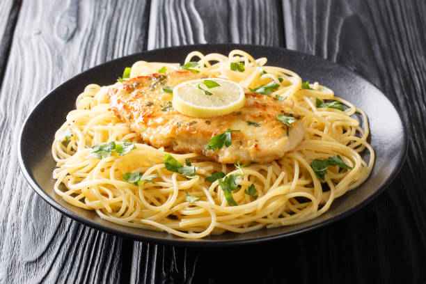 istock Roasted breaded chicken Francaise with a side dish of spaghetti close-up on a plate. Horizontal 1180244824