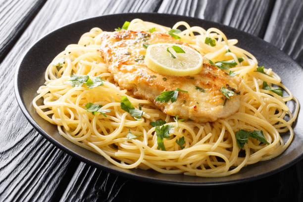 istock Authentic fried breaded chicken Francaise with spaghetti in lemon wine gravy close-up on a plate. horizontal 1180244834