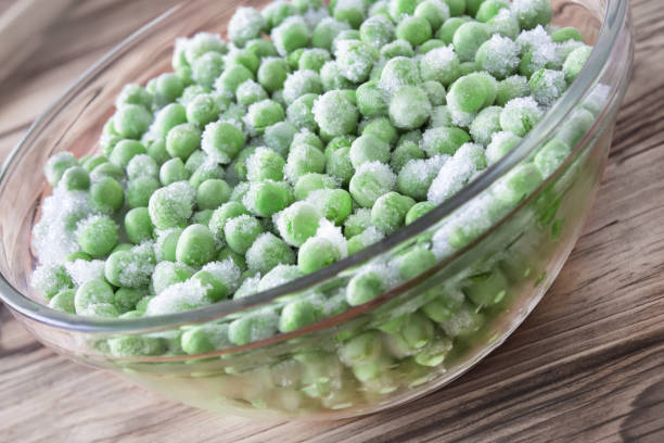 istock Frozen peas in bowl close-up background 1180245712