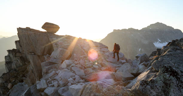 istock Mountaineer crosses summit ridge at sunrise 1180249810