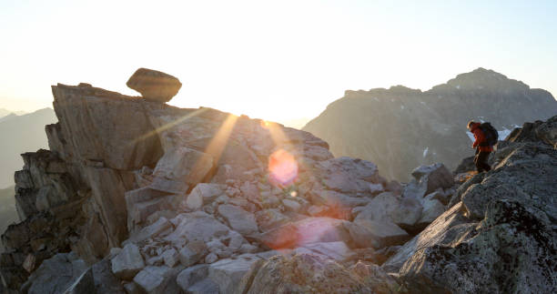 istock Mountaineer crosses summit ridge at sunrise 1180249811