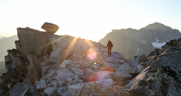 istock Mountaineer crosses summit ridge at sunrise 1180250178