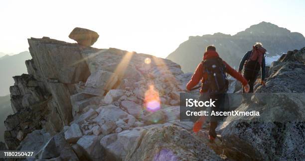 Two Mountaineers Traverse Summit Ridge At Sunrise Stock Photo - Download Image Now - Hiking, Extreme Sports, Men