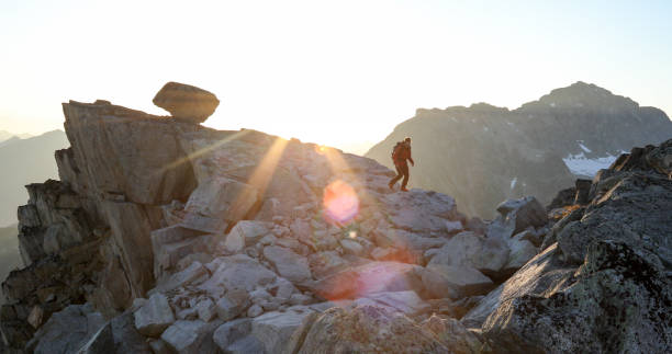 istock Mountaineer crosses summit ridge at sunrise 1180250435