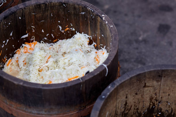 holzfass mit sauerkohl. dies ist ein nützliches fermentiertes produkt. sauerkohl ist reich an vitaminen und wird in vielen gerichten verschiedener nationen verwendet. der fermentationsprozess zerstört keine nährstoffe - sauerkraut salad coleslaw cabbage stock-fotos und bilder