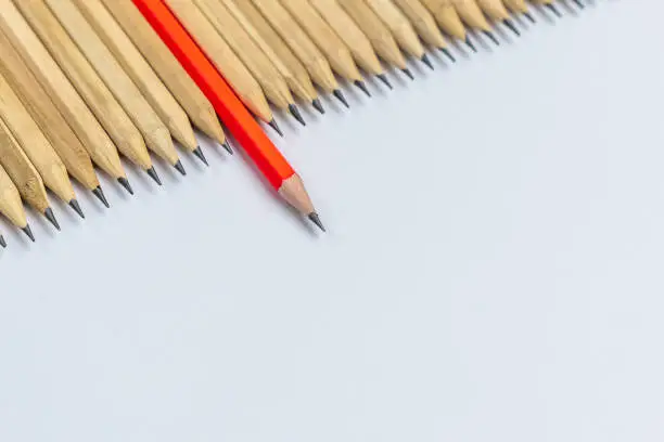 Different pencil standout from the others showing concept of unique business thinking different from the crowd and special one with leadership skill.