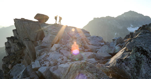 zwei bergsteiger überqueren gipfelkamm bei sonnenaufgang - 6721 stock-fotos und bilder