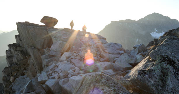 istock Two mountaineers traverse summit ridge at sunrise 1180251663
