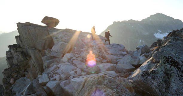istock Two mountaineers traverse summit ridge at sunrise 1180251969