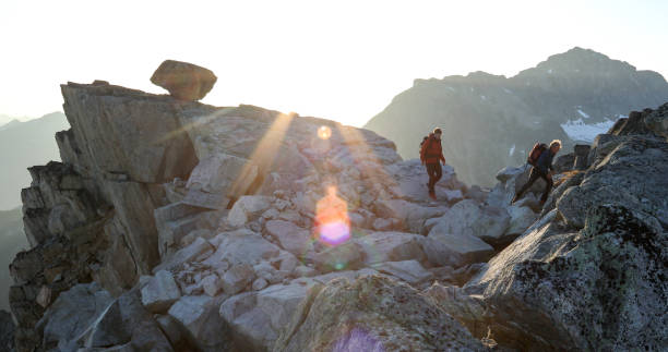 istock Two mountaineers traverse summit ridge at sunrise 1180252067