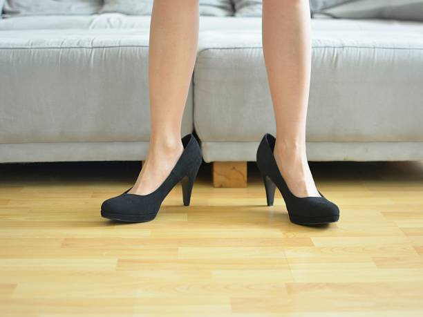 istock Woman wearing big black shoes 1180252115