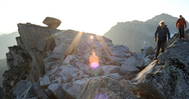 dos montañeros atraviesan la cresta de la cumbre al amanecer - 6727 fotografías e imágenes de stock