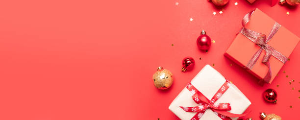 istock Creative composition with gifts or presents boxes with gold bows and star confetti on red background top view. Flat lay composition for birthday, christmas or wedding. 1180253129