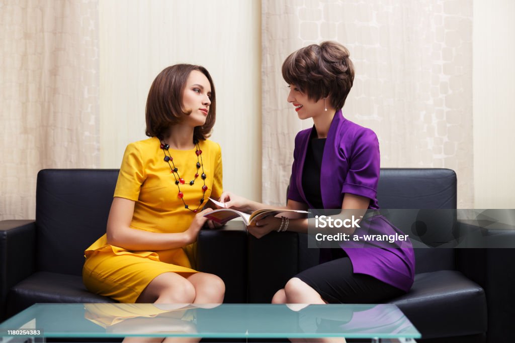 Zwei junge Mode-Business-Frauen sitzen auf der Couch im Showroom - Lizenzfrei Büro Stock-Foto