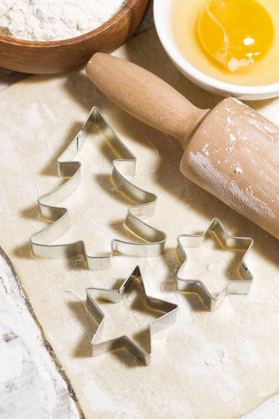 istock Ingredients for baking Christmas cookies on table. Dough, cookie cutters and rolling pin, top view 1180254568