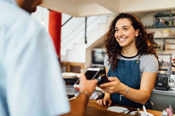 Contactless Payment in Coffee shop Client pays contactless at coffeeshop paid stock pictures, royalty-free photos & images