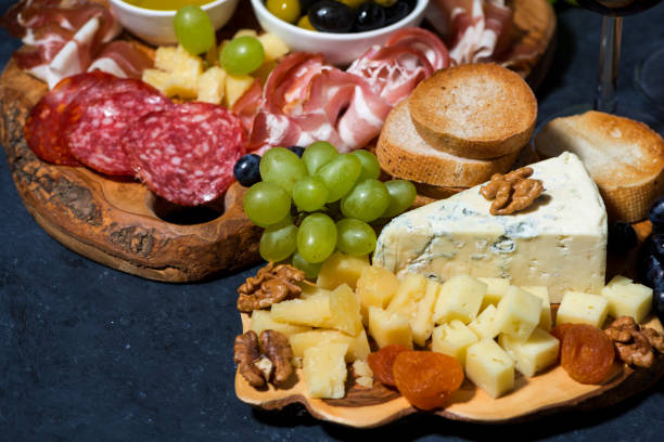 istock cheese platter on a wooden board, bread, fruit and cold cuts 1180255121