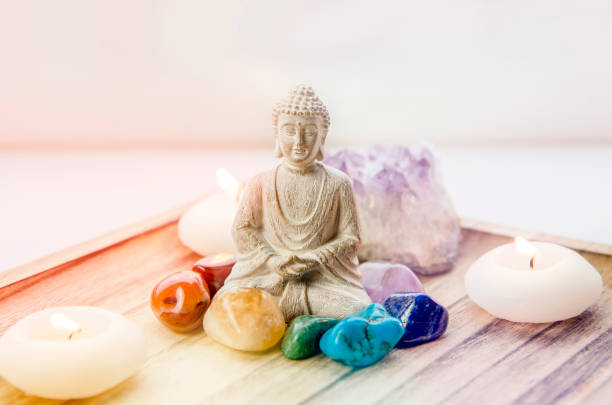 All seven chakra colors crystals stones around sitting Buddha figurine on natural wooden tray. Balance and calm energy flow in home concept. All seven red, orange, green, blue, purple chakra colors crystals stones around sitting Buddha figurine on natural wooden tray. Balance and calm energy flow in home concept. crystal altar stock pictures, royalty-free photos & images