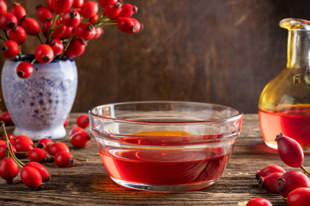 istock Rosehip seed oil in a bowl with fresh rose hips 1180257732