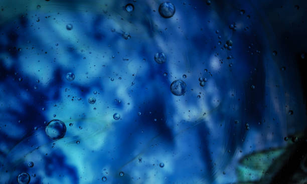 istock Oil drops on a water surface - Water bubbles abstract light illumination 1180257926