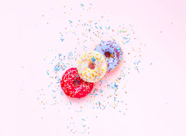 istock Colored donuts with colorful sprinkles on pink background. Concept colorful breakfast. Copy space 1180259244