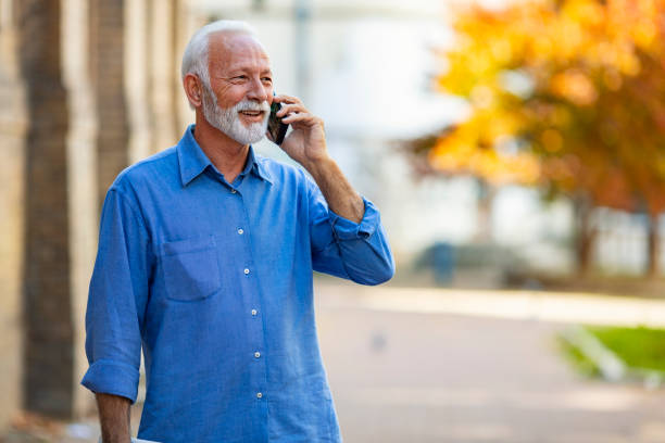 istock Happy bearded senior man talking by phone. 1180261682