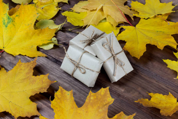 istock gift boxes among autumn leaves on a wooden surface 1180262046