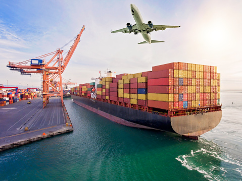 Airplane flying over container port