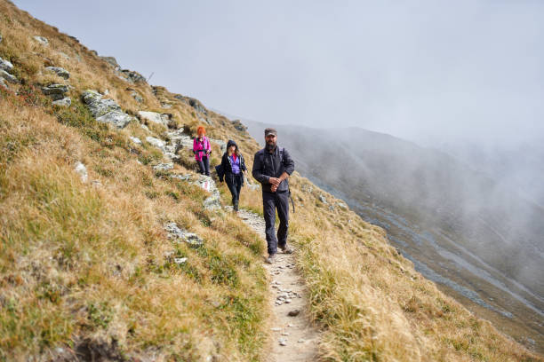 istock People with backpacks hiking into the mountains 1180266709