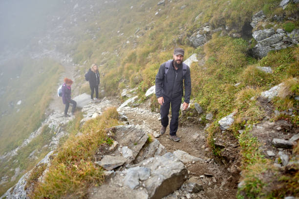 istock People with backpacks hiking into the mountains 1180266716
