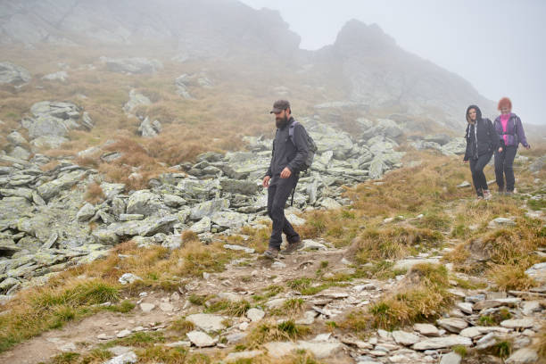 istock People with backpacks hiking into the mountains 1180266723