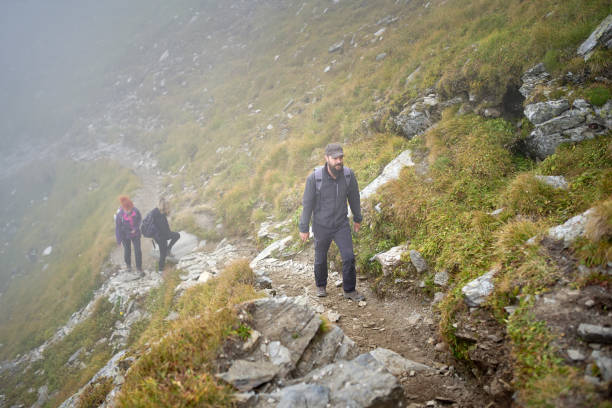 istock People with backpacks hiking into the mountains 1180266726
