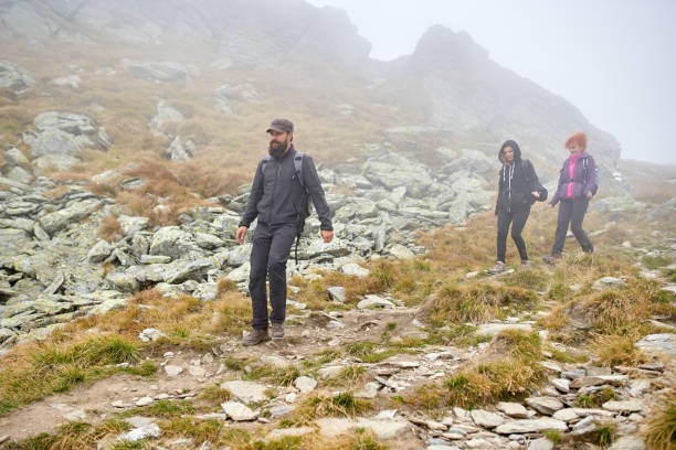istock People with backpacks hiking into the mountains 1180266727