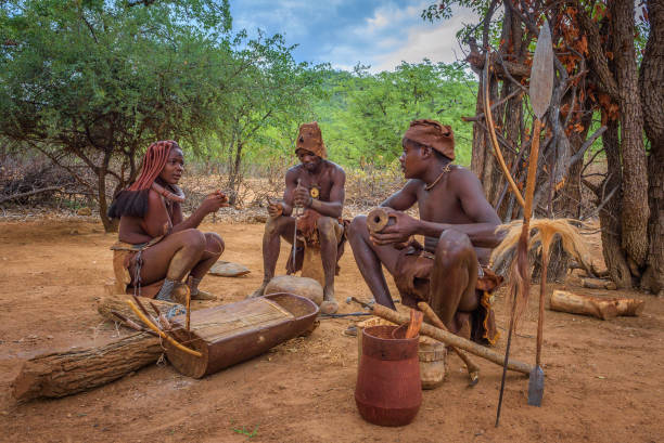 People of the Himba tribe sitting and making their tools Opuwo, Namibia - March 31, 2019: People of the Himba tribe sitting and making their tools. The Himba people are indigenous tribe living in northern Namibia. kaokoveld stock pictures, royalty-free photos & images