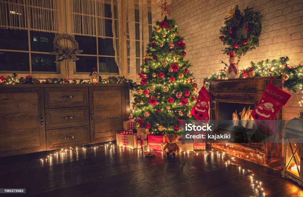 Decorated Christmas Tree Near Fireplace at Home Christmas tree near fireplace in decorated living room Christmas Stock Photo