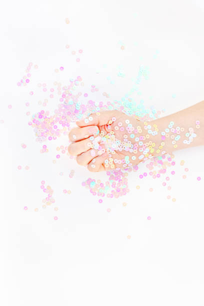 istock Pearl pastel confetti sparkles with woman hand 1180276717