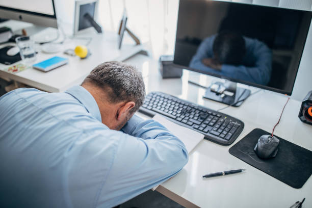 istock Tired senior businessman sleeping at the office desk 1180276868