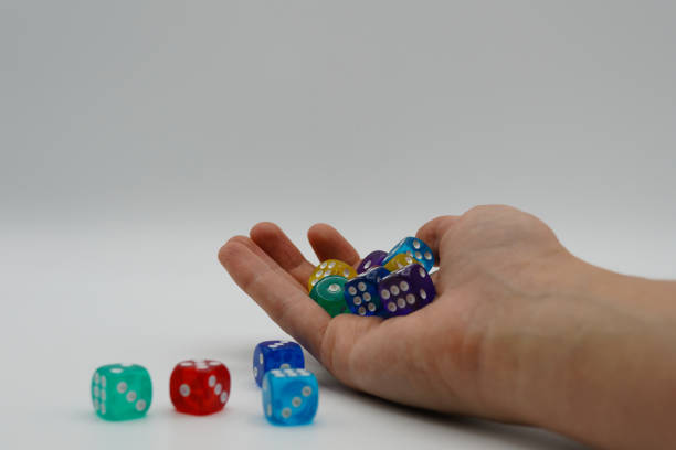 istock Chaos in the universe, logic thinking and human brain. Woman's hand throwing game cubes on white background and mixing them chaotically. Shaking hand with square cubes in 4K 1180279157