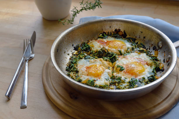 szpinak z jajkiem sadzonym i przyprawami, bogate w białko danie wegetariańskie do diety niskowęglowodanowej na rustykalnym drewnianym desce - spinach salad fork low carb diet zdjęcia i obrazy z banku zdjęć