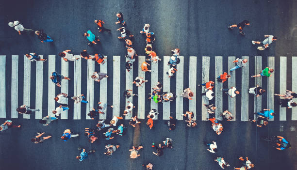 Aerial. People crowd motion through the pedestrian crosswalk. Top view from drone. Toned image. stock photo