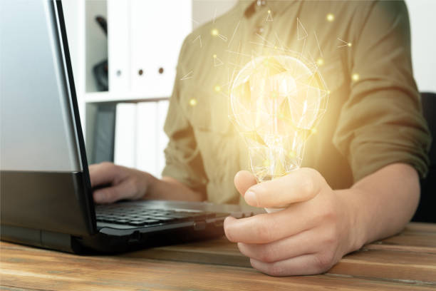 istock Idea and creativity concept. Businesswomen holding light bulb with futuristic low poly graphic 1180280332