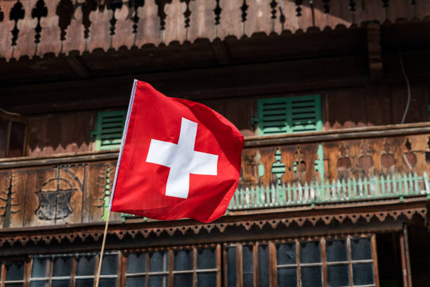Swiss flag in front of a traditionnal mountain chalet