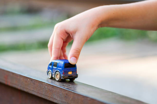 kinder kind spielen blaue farbe autospielzeug. kind hand spielen mit auto - spielzeugauto stock-fotos und bilder