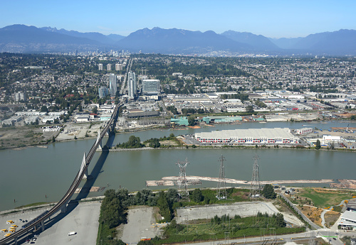 High angle view of the North Arm of the Fraser River between Richmond and Vancouver. The Canada Line Bridge or North Arm Bridge carries the Canada Line train, pedestrians and cyclists to Cambie Street.