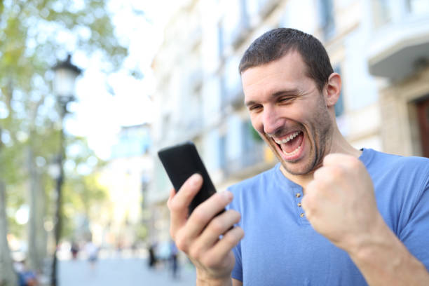 istock Excited man celebrating good news checking phone 1180289113